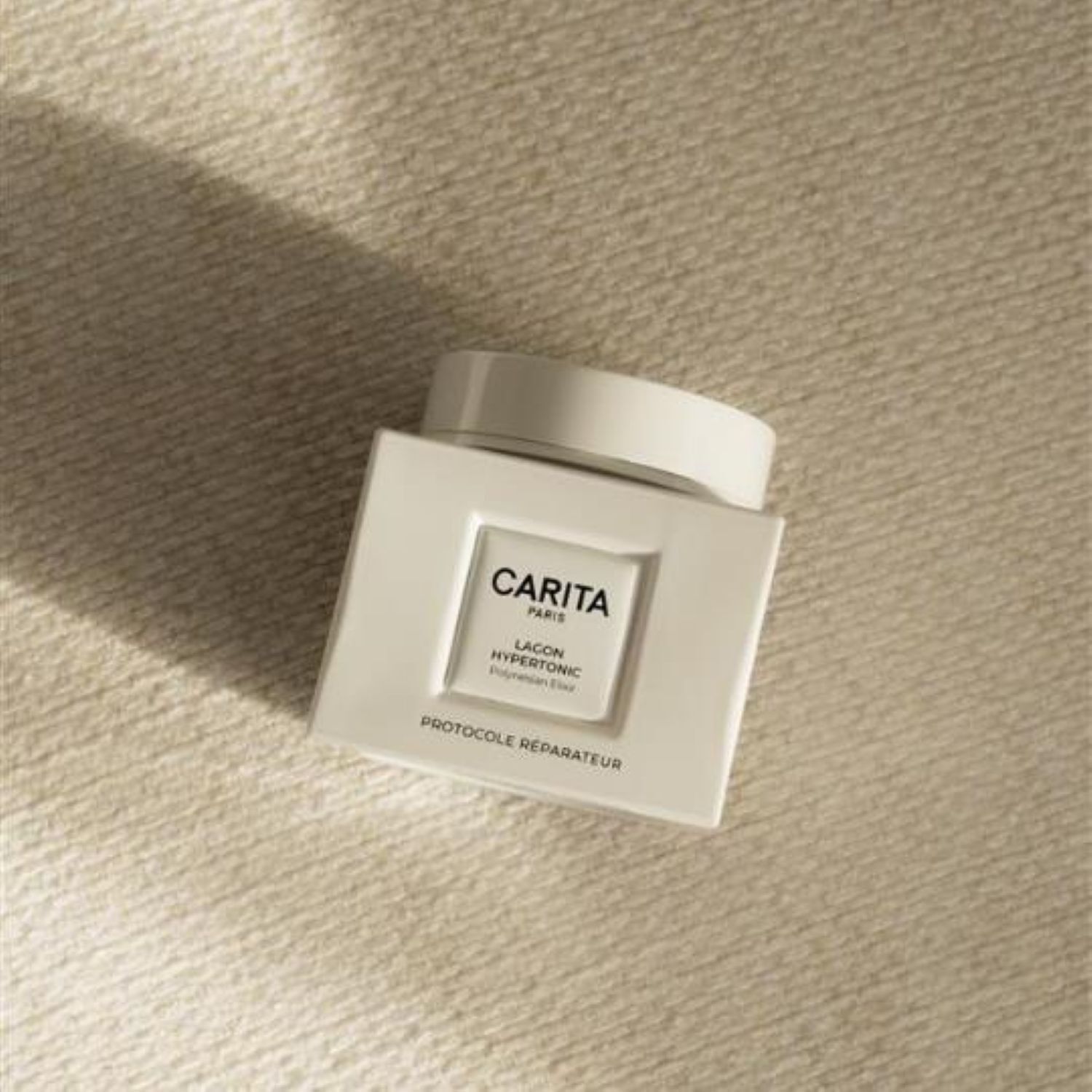 White jar of Carita Paris Lagon Hypertonic Polynesian Elixir, indicating 'Protocole Reparateur', designed for skin repair and rejuvenation 
