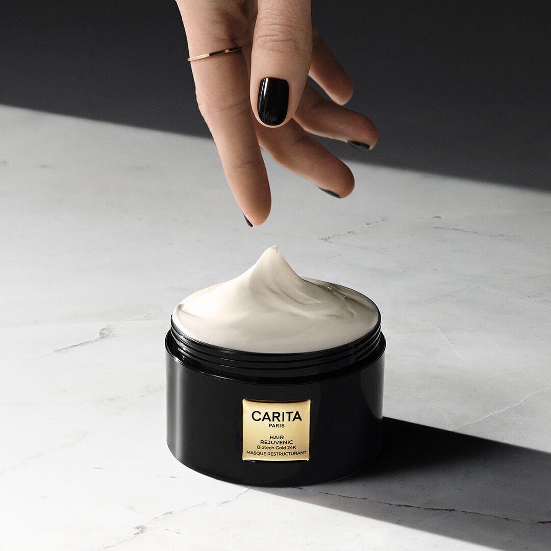 Hand scooping the Light-Fusion Restructuring Hair Mask cream.