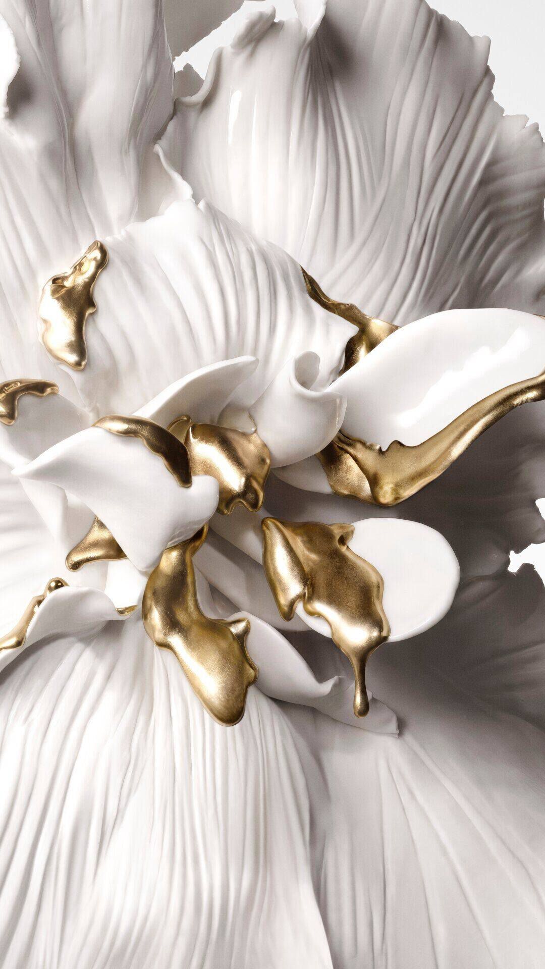 A white sculpted flower with 24K Biotech Gold detailing.