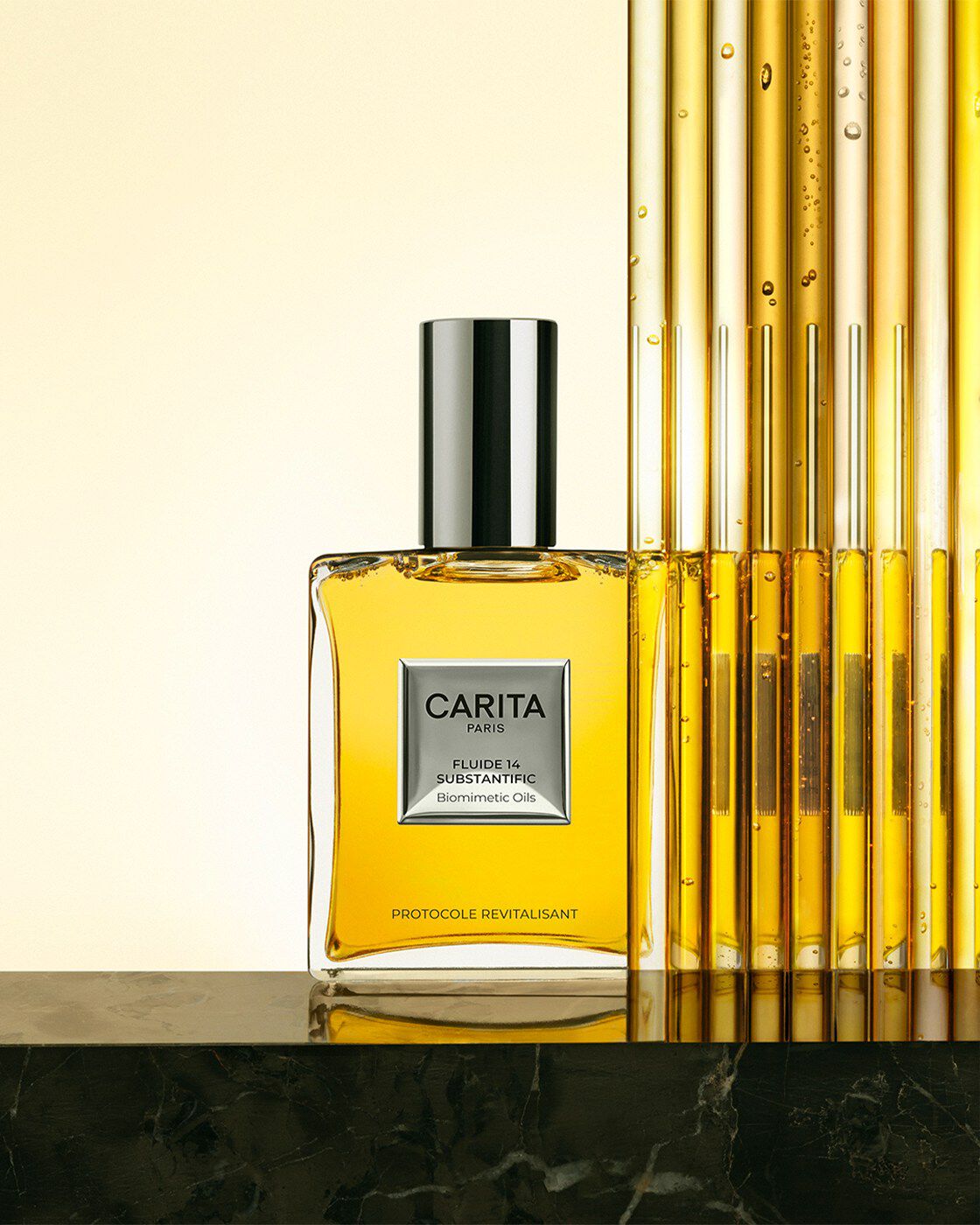 Luxury glass bottle of Carita Fluide 14 containing golden oil. The product stands on dark marble next to sleek vertical glass tubes, evoking a premium laboratory and revitalizing protocol.​