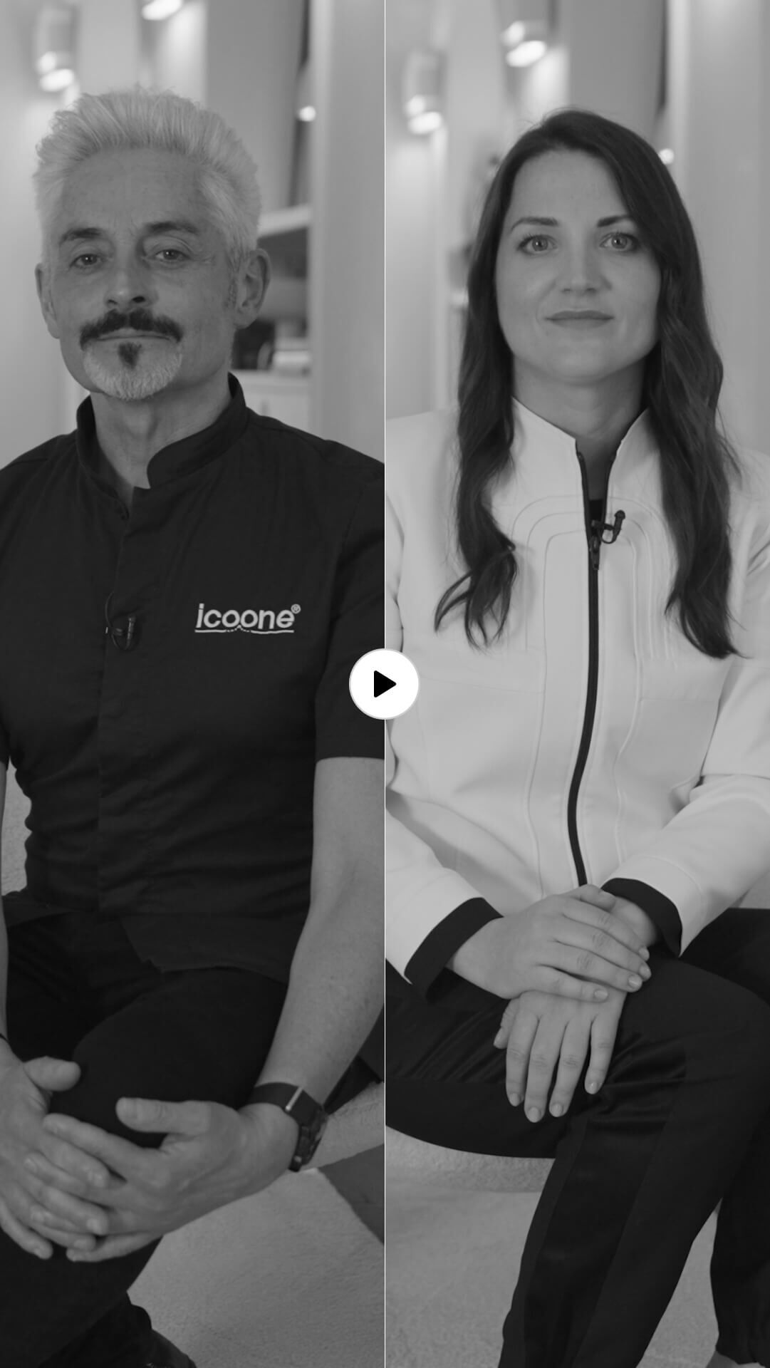 B&W photo of a man and a woman, seemingly an interview. The man with gray hair and beard wears an "Icoone" polo. The long-haired woman wears a light jacket. Play button in the center.