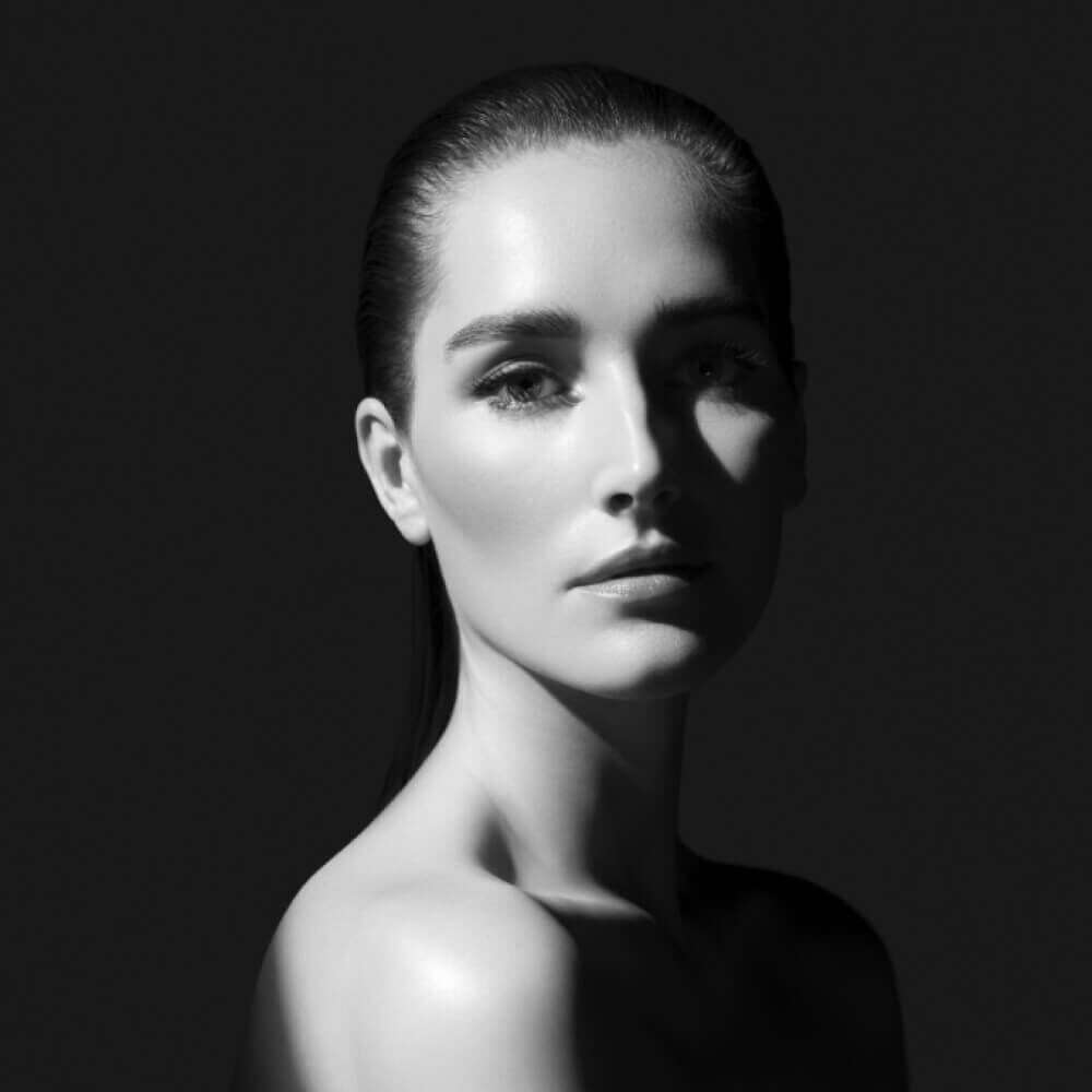  Black and white portrait of a woman with dramatic lighting.
