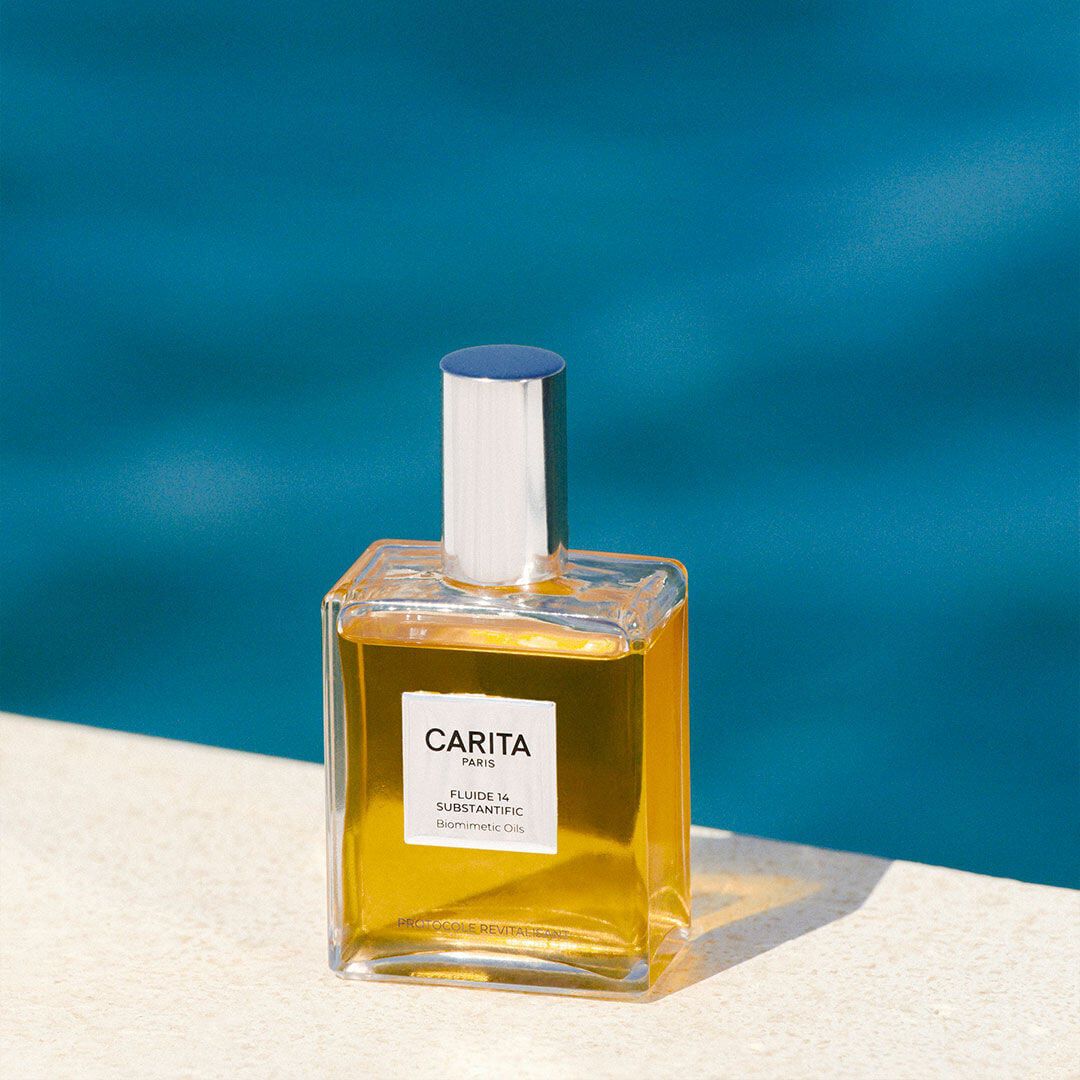 Golden Fluide 14 bottle with the sea in the background.