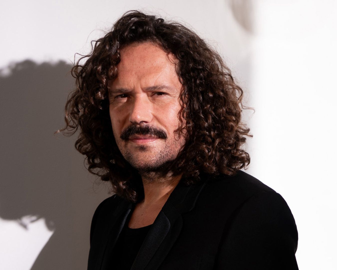 A portrait of ambassador hairdresser David Lucas wearing a black jacket.