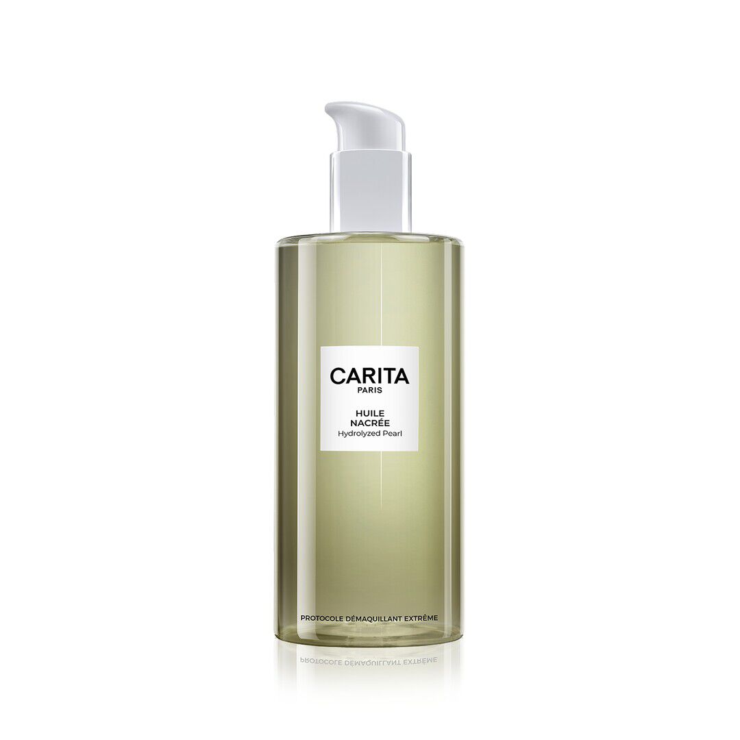 A transparent pump bottle of Carita Pearly Oil "Protocole Demaquillant Extreme". Its slightly golden hue and sleek design emphasize the purity and effectiveness of a luxurious makeup removal.