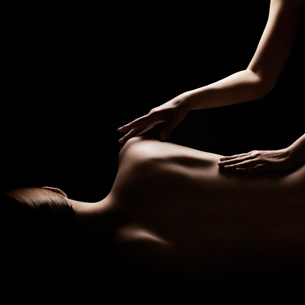 Dramatic high-contrast shadows over a professional back massage.